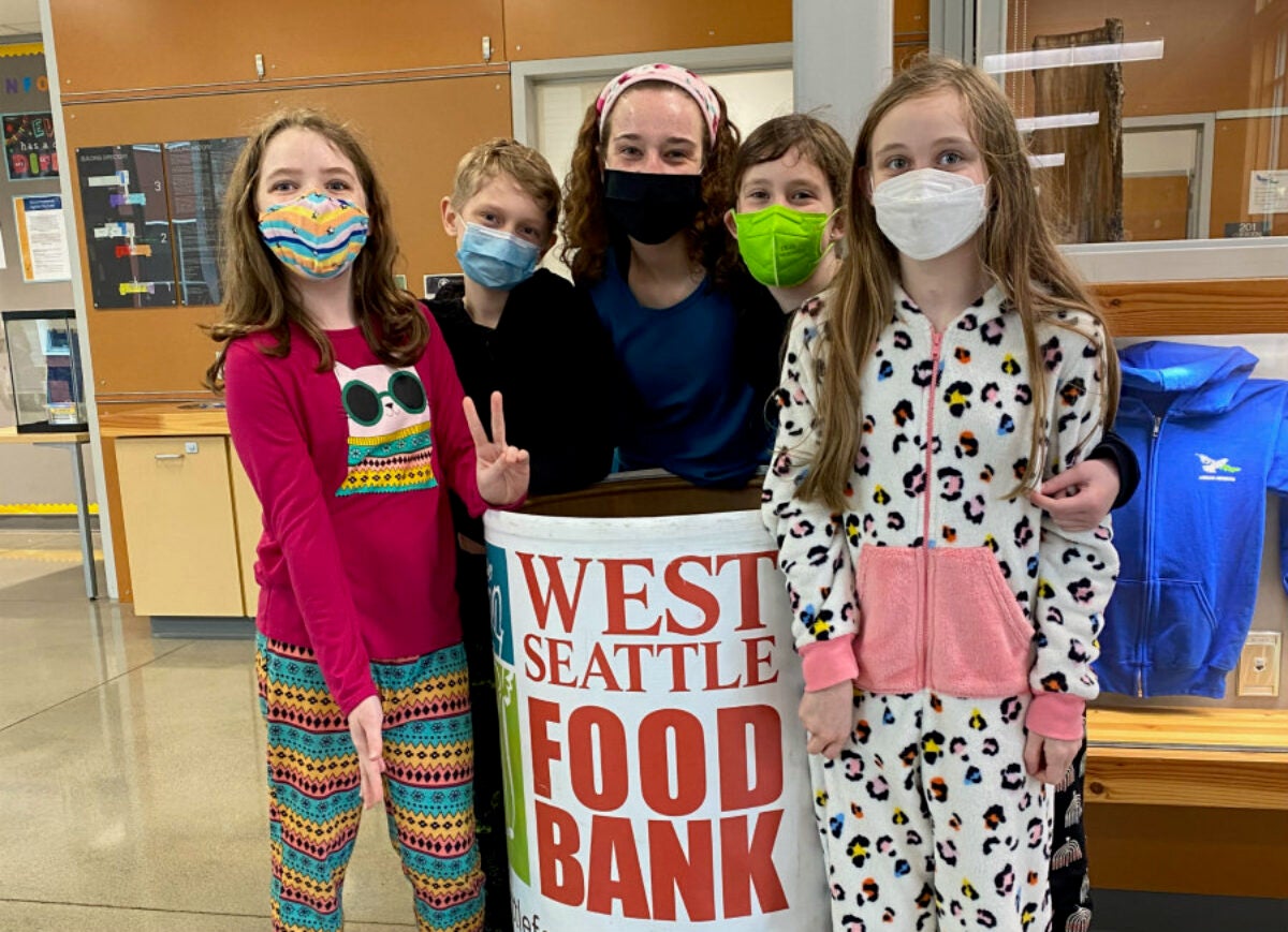 five organizers of food drive with food collection bin