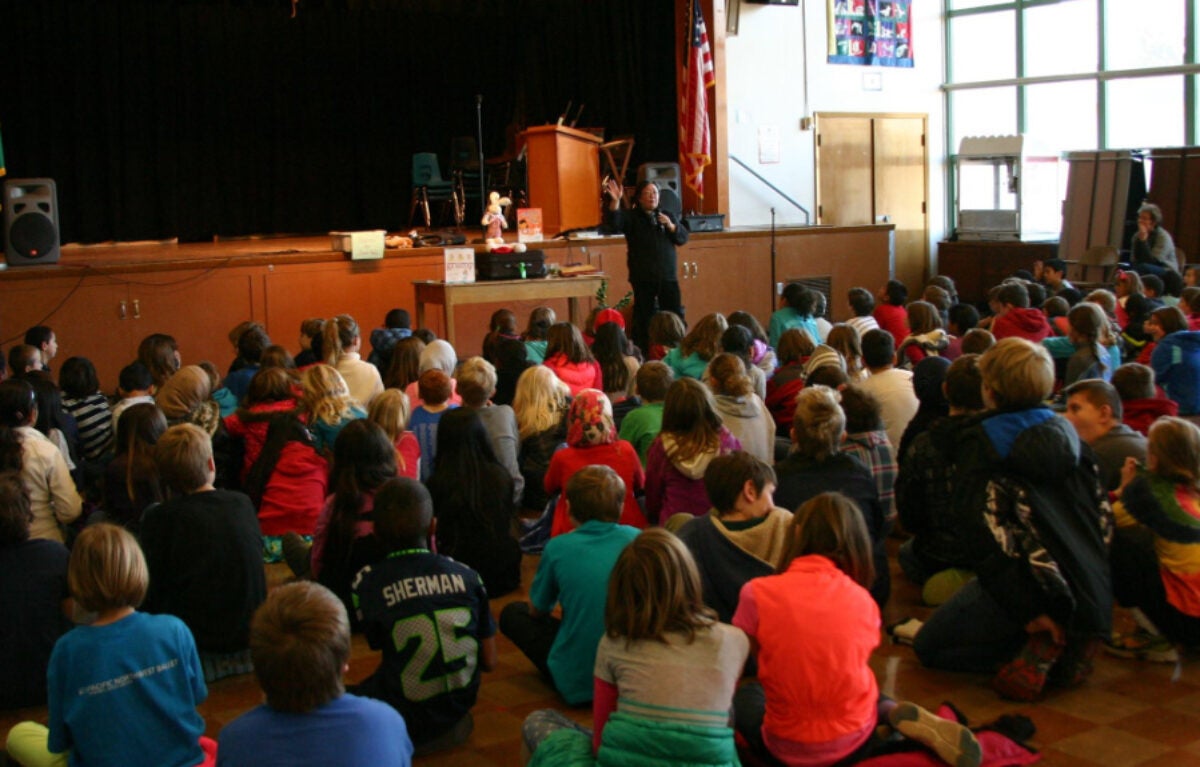 Janet Wong presenting to a group of elementary students in a school cafeteria