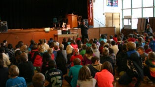 Janet Wong presenting to a group of elementary students in a school cafeteria